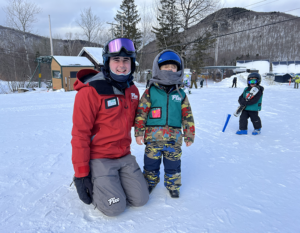 Learning how to ski, a young boy and his instructor