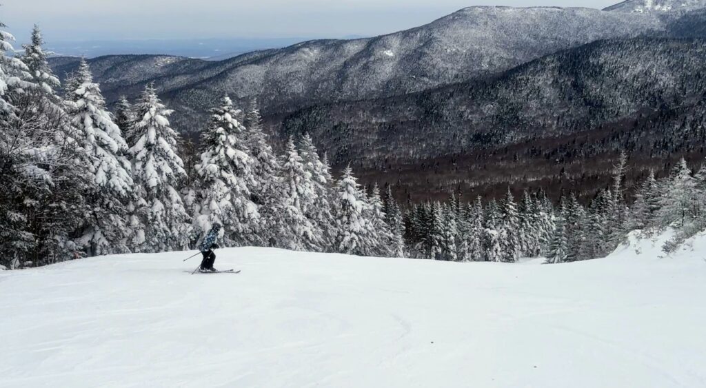 Woman skiing a blue square intermediate run at Bolton Valley