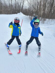 Young boys on skis give a thumbs up to Mom for Grammy Jay at Jay Peak